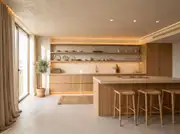 Wide architectural shot of a Japandi apartment kitchen with open oak shelving, microcement floors, and an olive tree.