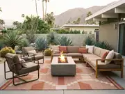 Beige sectionals around a square fire pit on a desert patio with a red patterned rug, cacti and mountain views at sunset