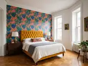 Bedroom with a tufted mustard-yellow headboard, white bedding, two bedside lamps, and a floral leaf-pattern accent wall