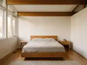 Honey-oak bed frame, nightstand, and round side table repeating one matching wood tone