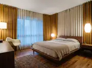 Small bedroom with floor-to-ceiling drapery panels mounted at the ceiling above a platform bed