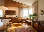 Room perspective of a Mid-Century Modern kitchen with an integrated leather banquette and warm walnut millwork.