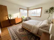 Small bedroom with a patterned area rug sized to the walkway, leaving bare floor at the edges