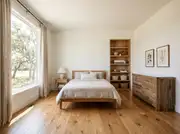 Small, uncluttered farmhouse-style bedroom with clear surfaces, a built-in bookshelf, and framed art