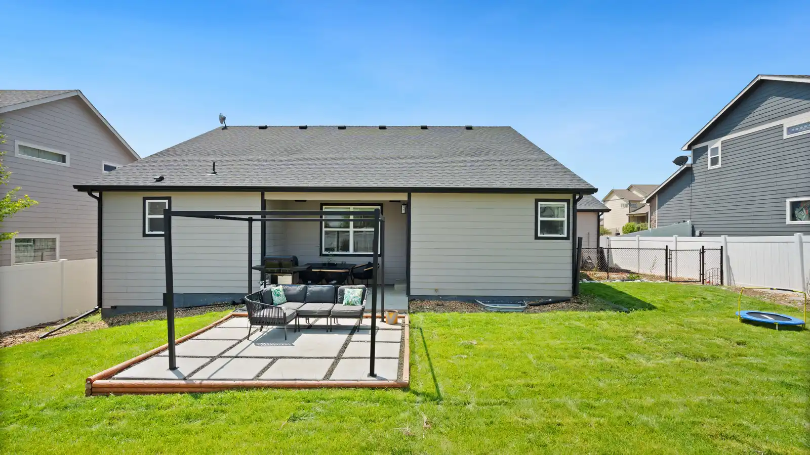 A bare aluminum patio cover kit frame standing freestanding next to a house before roofing
