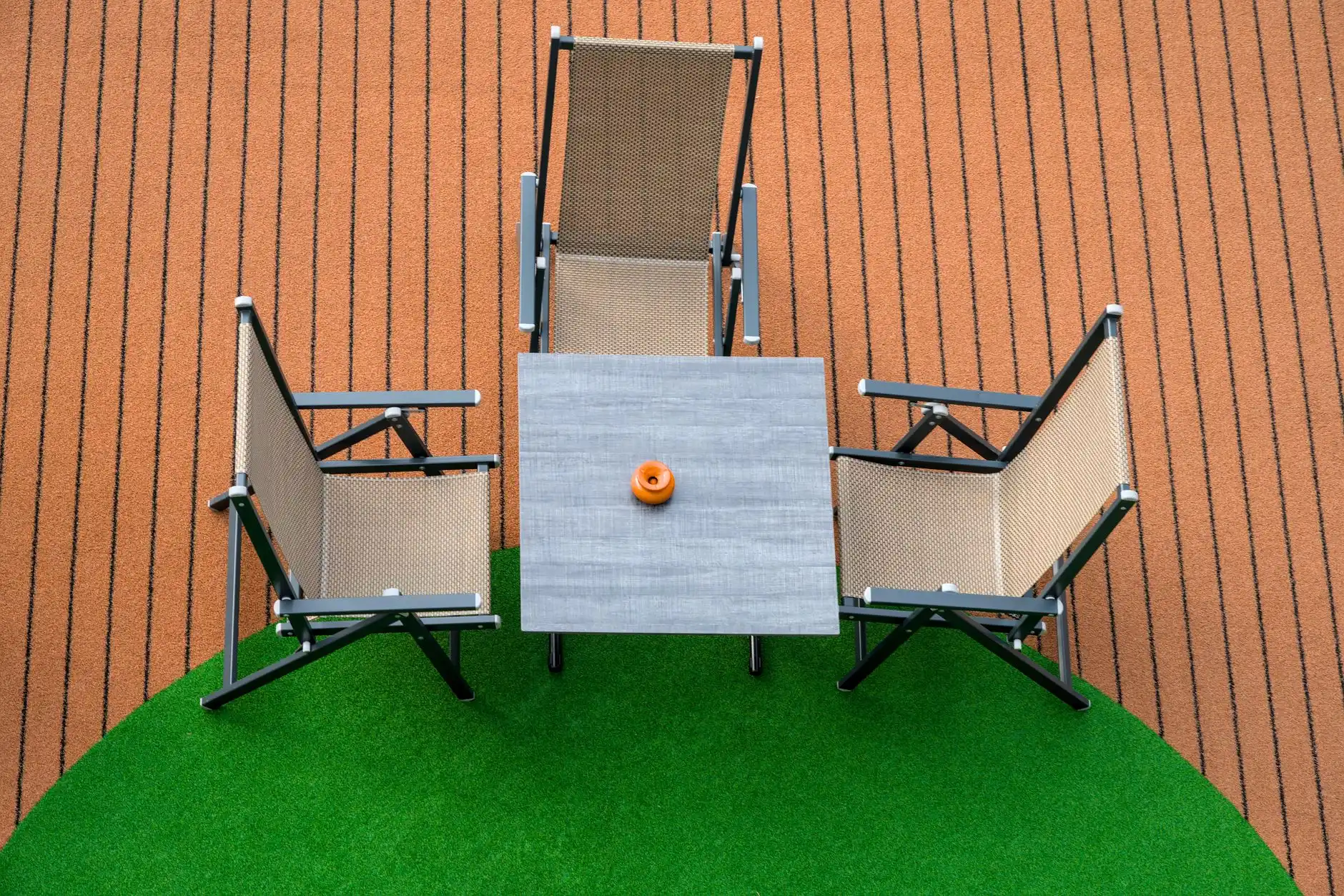 A circle of artificial turf under patio furniture in a no-grass backyard
