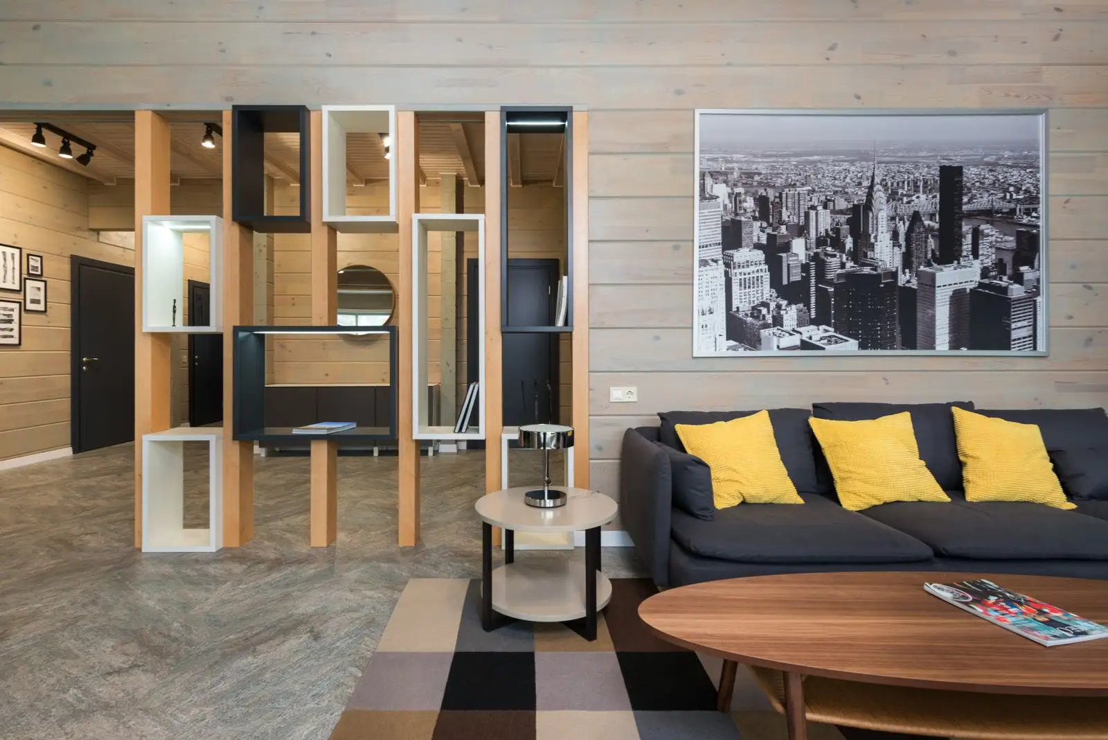 An open cube bookcase used as a room divider between the sofa and hallway in a small apartment