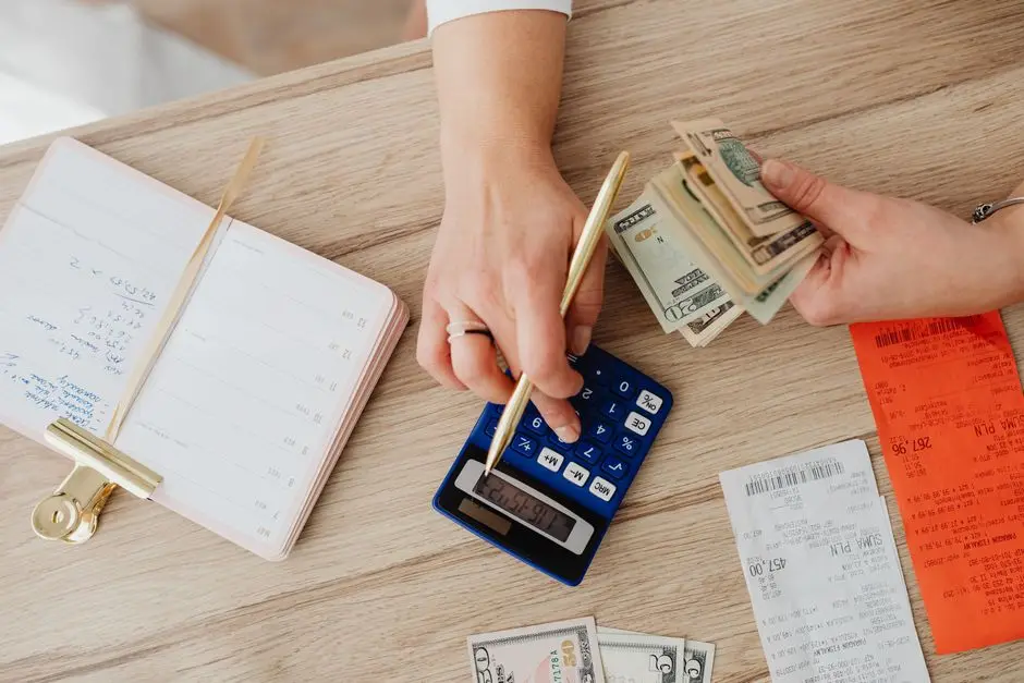 A calculator and receipts on a wood desk, tallying the honest budget for organic modern living room decor ideas
