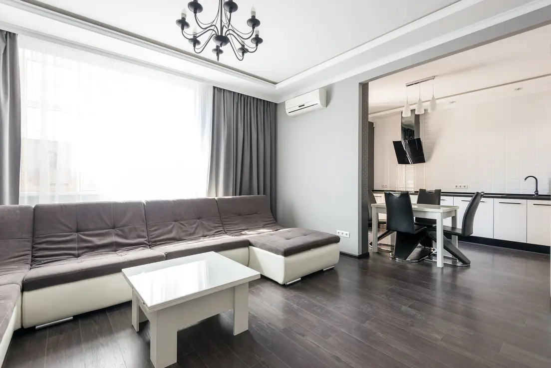 A simple, uncluttered apartment living room with a neutral sofa done on a modest budget
