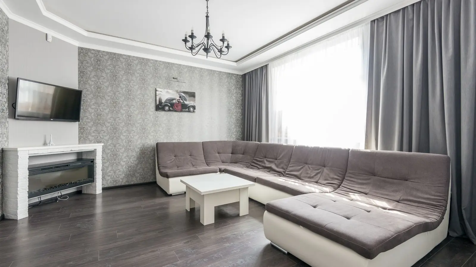 A small apartment living room styled with a sectional sofa on a modest budget