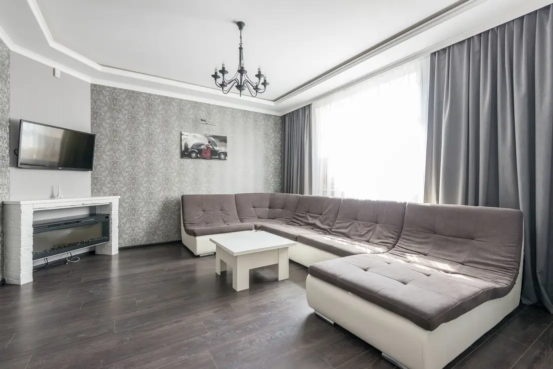 A small apartment living room styled with a sectional sofa on a modest budget