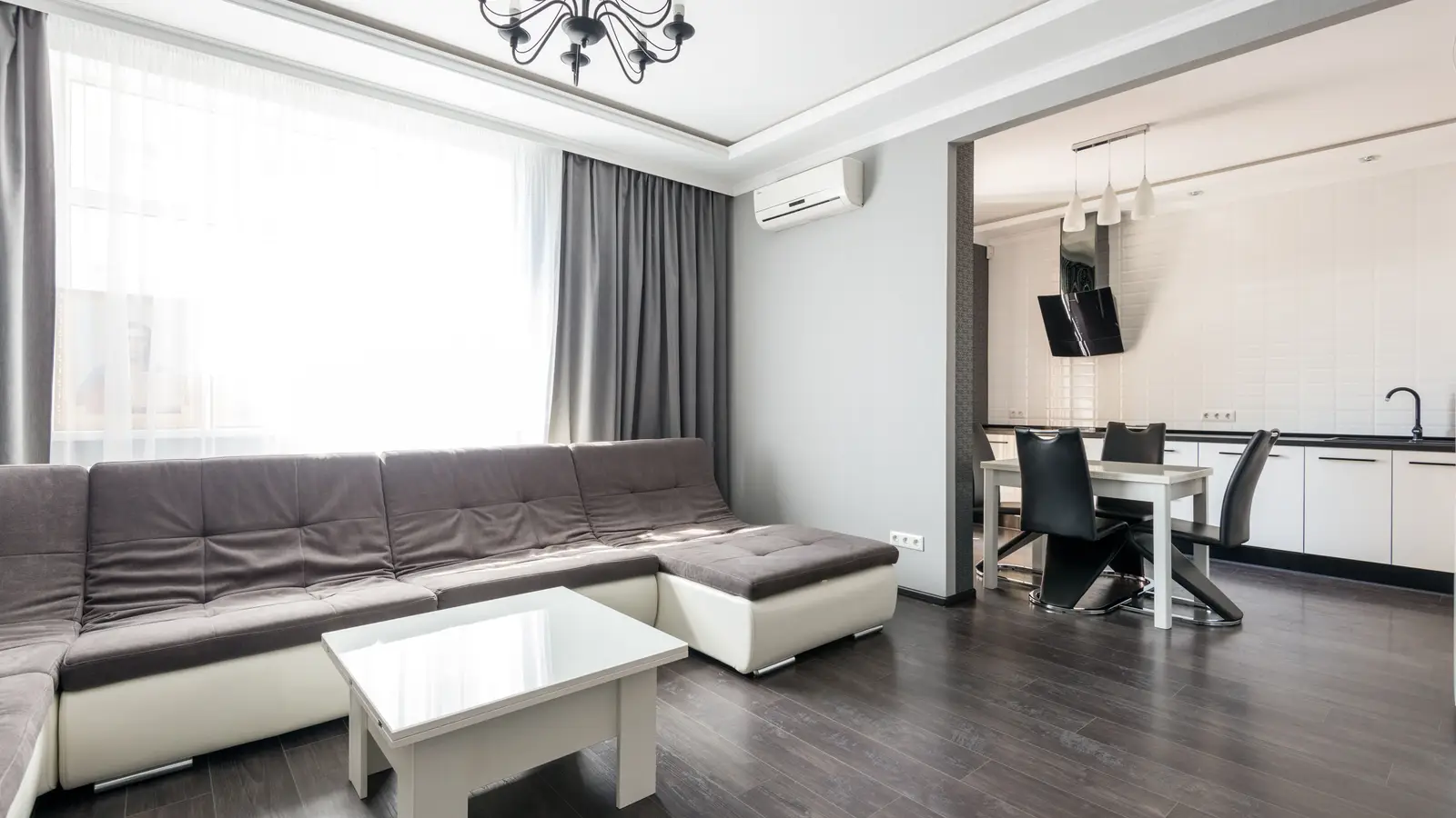 A simple, uncluttered apartment living room with a neutral sofa done on a modest budget
