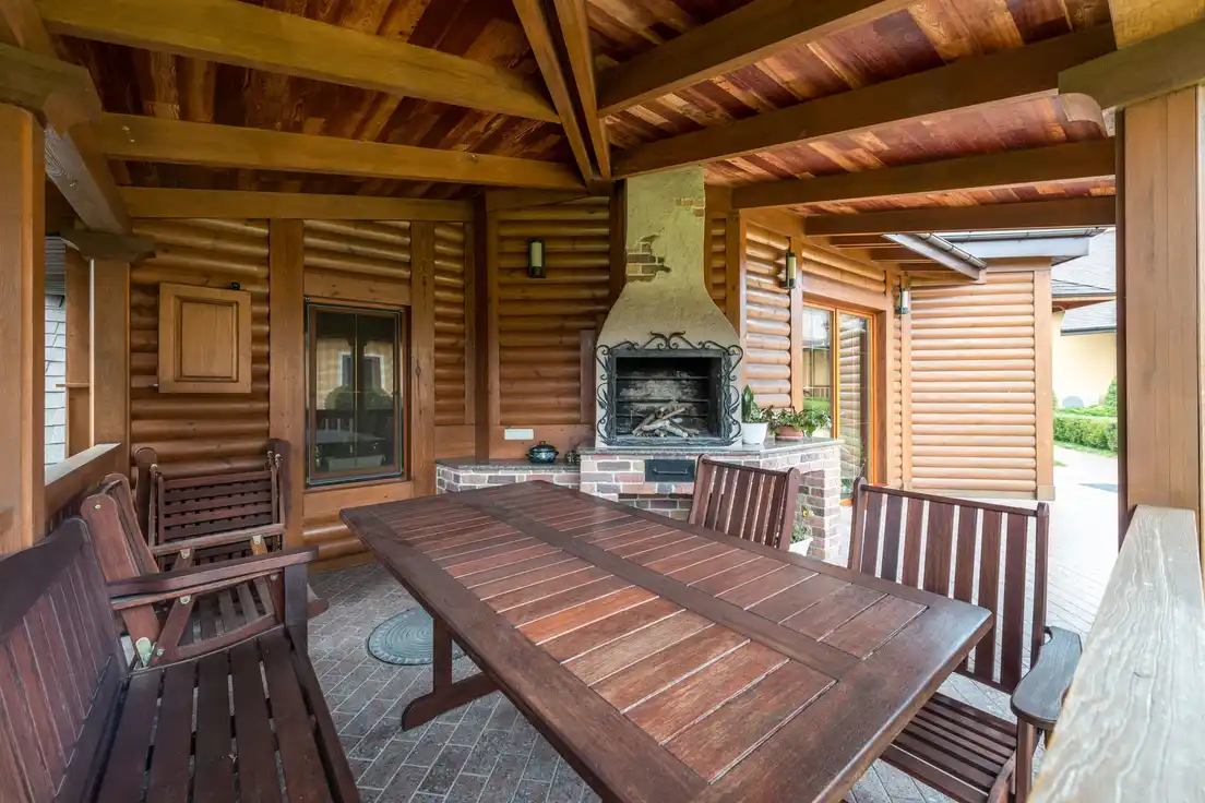 A wood patio cover with cedar plank ceiling and timber beams over an outdoor dining table