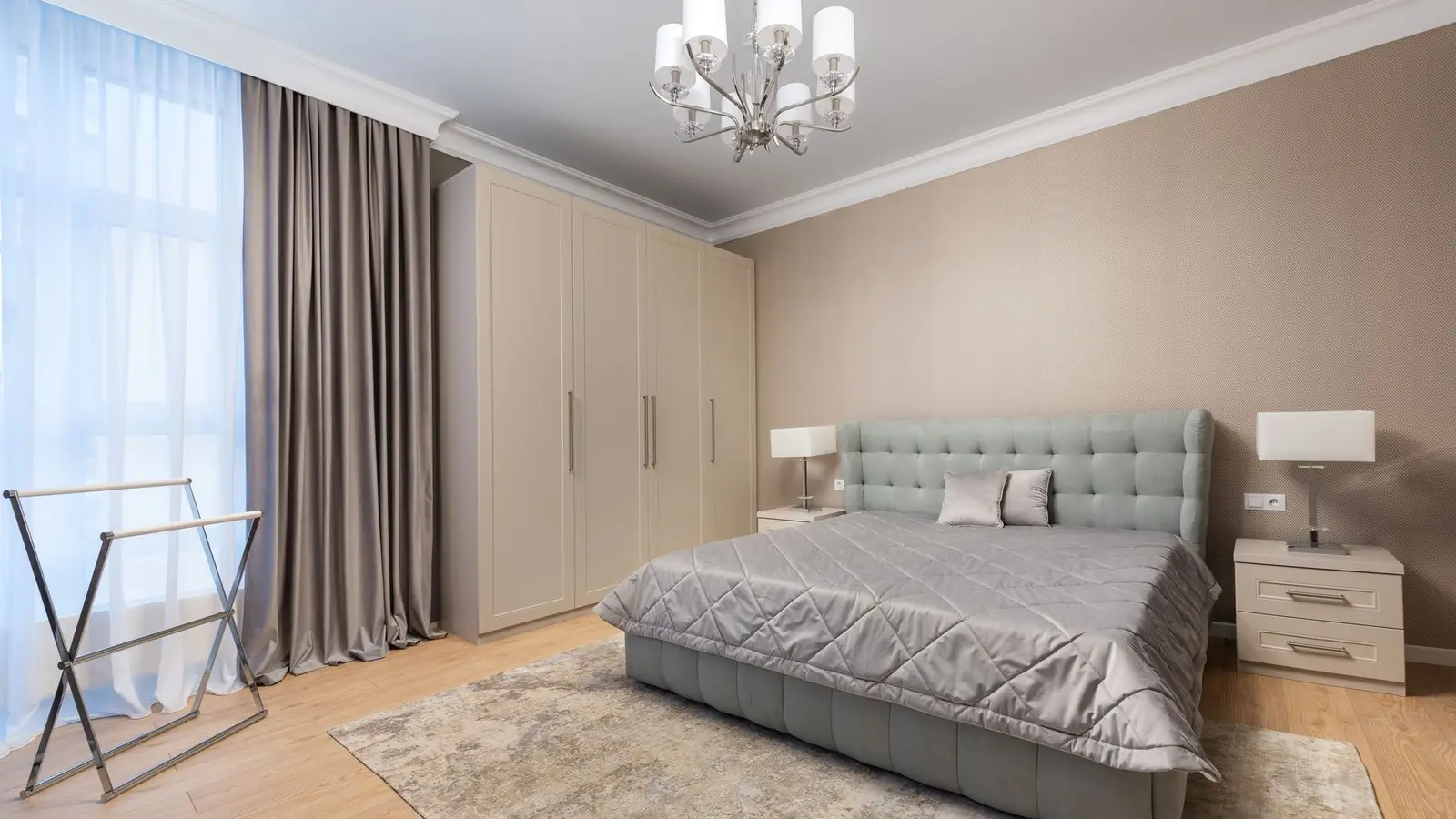 A small primary bedroom with the bed centered on the room's longest wall between two nightstands