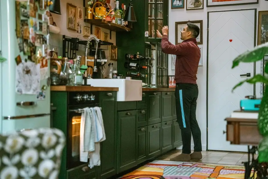 A man organizing shelves in a colorful, lived-in home kitchen