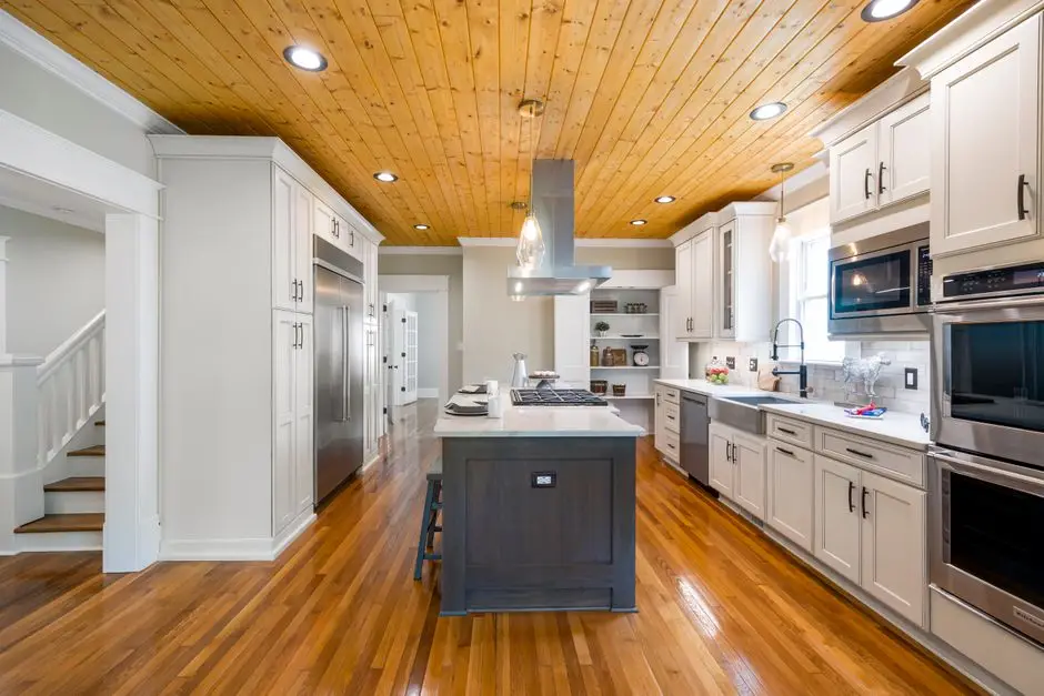 Kitchen cabinetry running to the ceiling with a wood-plank ceiling above