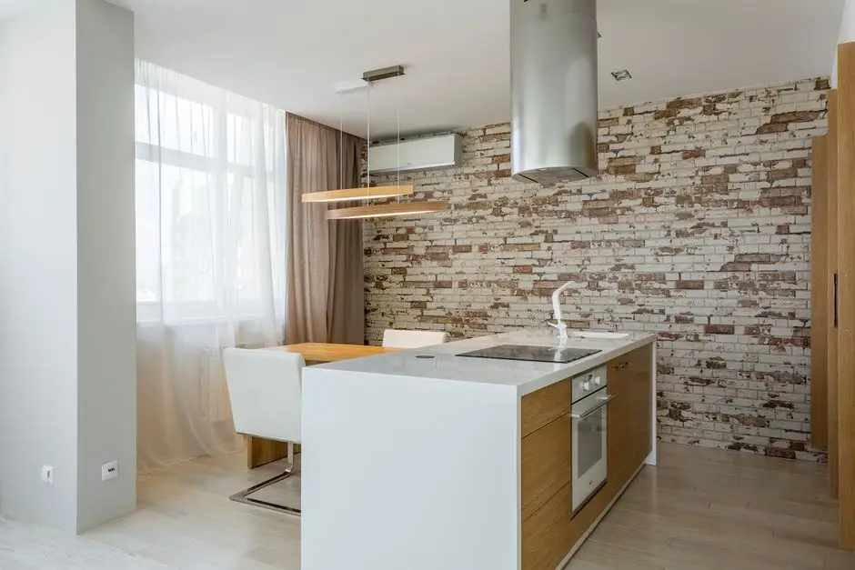 An open floor plan kitchen with a brick accent wall zoned off from the dining area