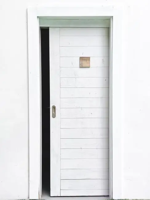 A white sliding pocket door in a closed kitchen doorway