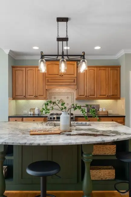 A closed kitchen with a wood island and pendant lighting
