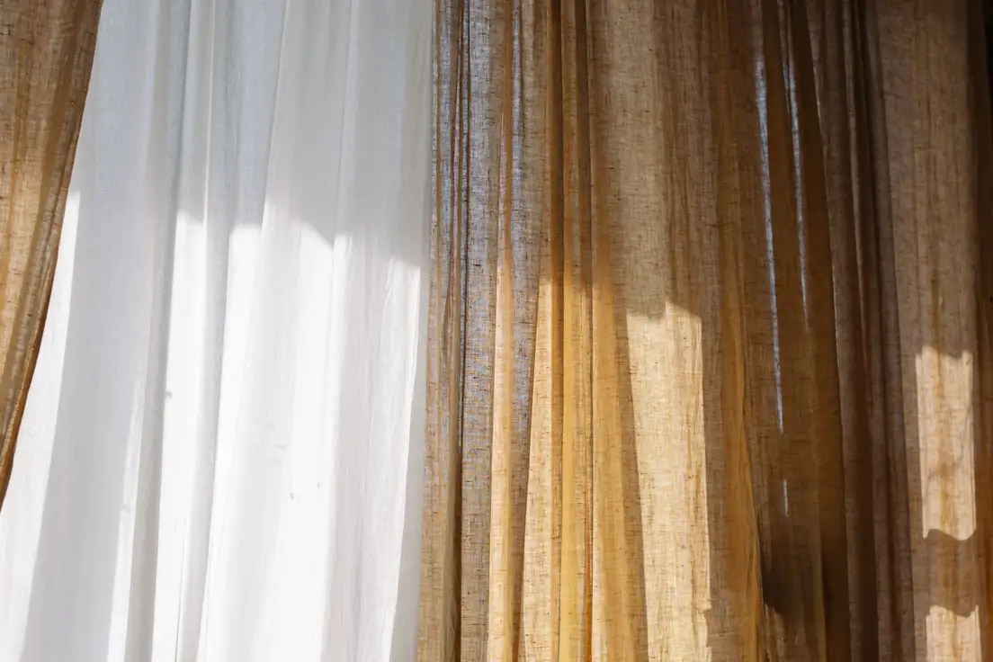 Sheer white and natural flax linen curtains in sunlight, a neutral base for organic modern decor