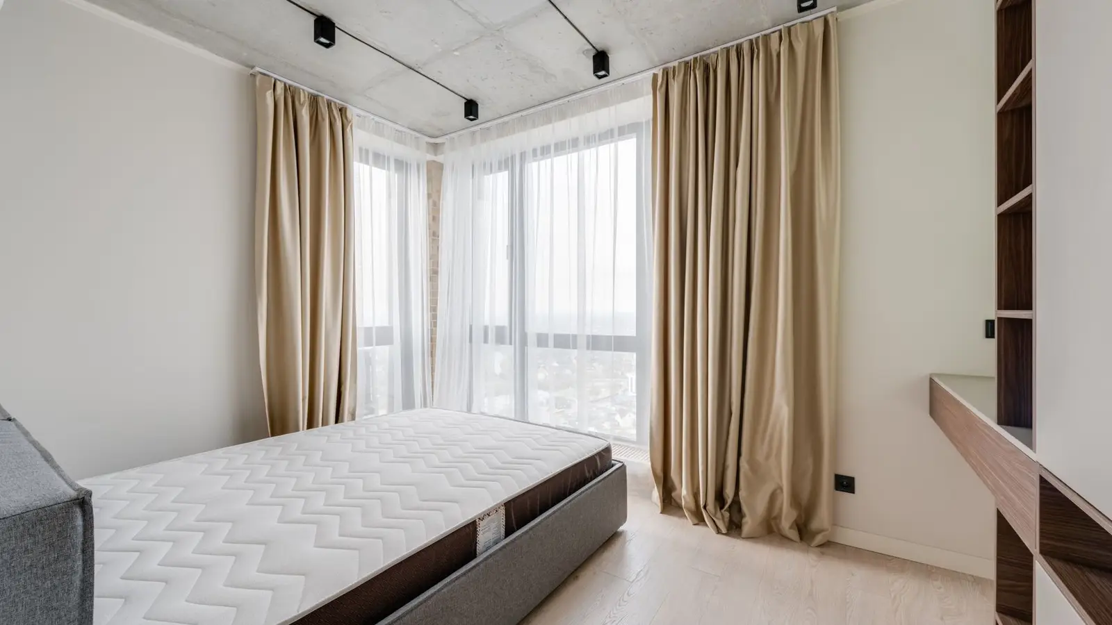 Floor-to-ceiling drapery panels in a small bedroom with a large window