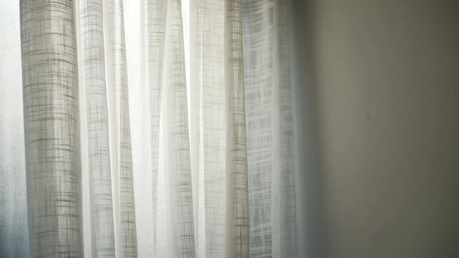 Sheer linen curtains with a subtle woven texture lit by soft daylight