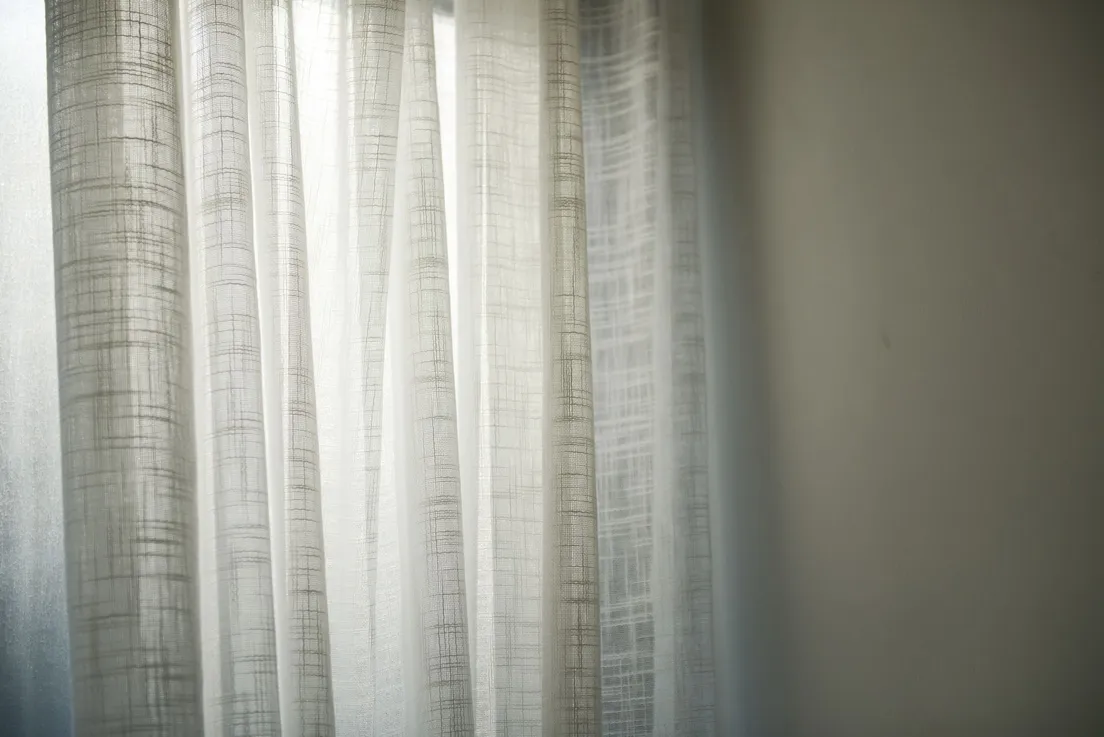Sheer linen curtains with a subtle woven texture lit by soft daylight