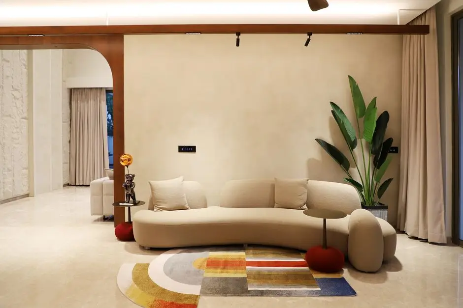 A curved, organic-shaped cream sofa against a warm plaster wall in a modern living room