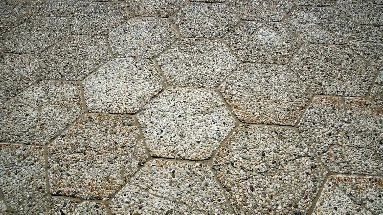 Decorative hexagonal exposed-aggregate concrete pavers on a patio