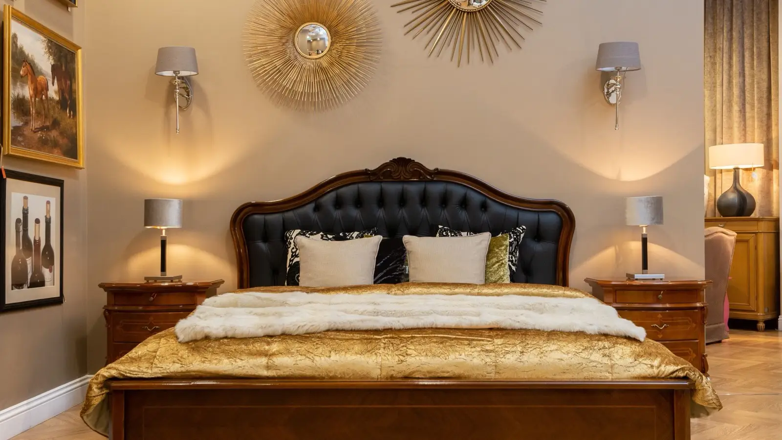 A gold quilted bedspread layered with a white faux-fur throw and patterned pillows