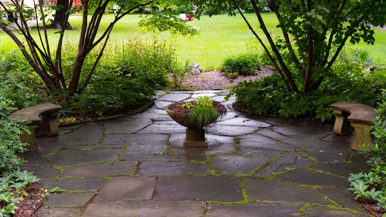 An irregular flagstone patio path through a shaded garden