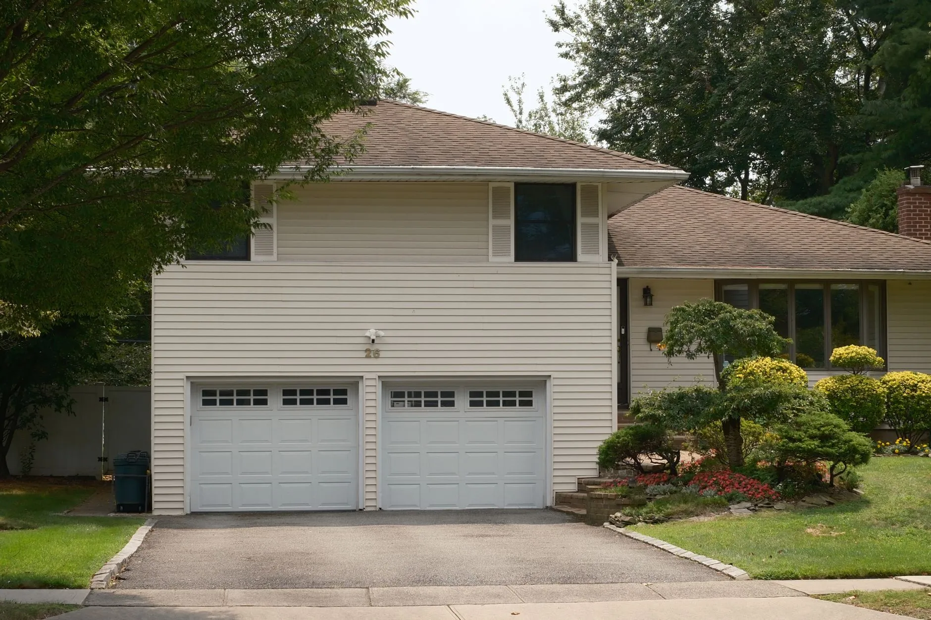 A dated flat-panel garage door on a house exterior, the kind a modern farmhouse makeover replaces