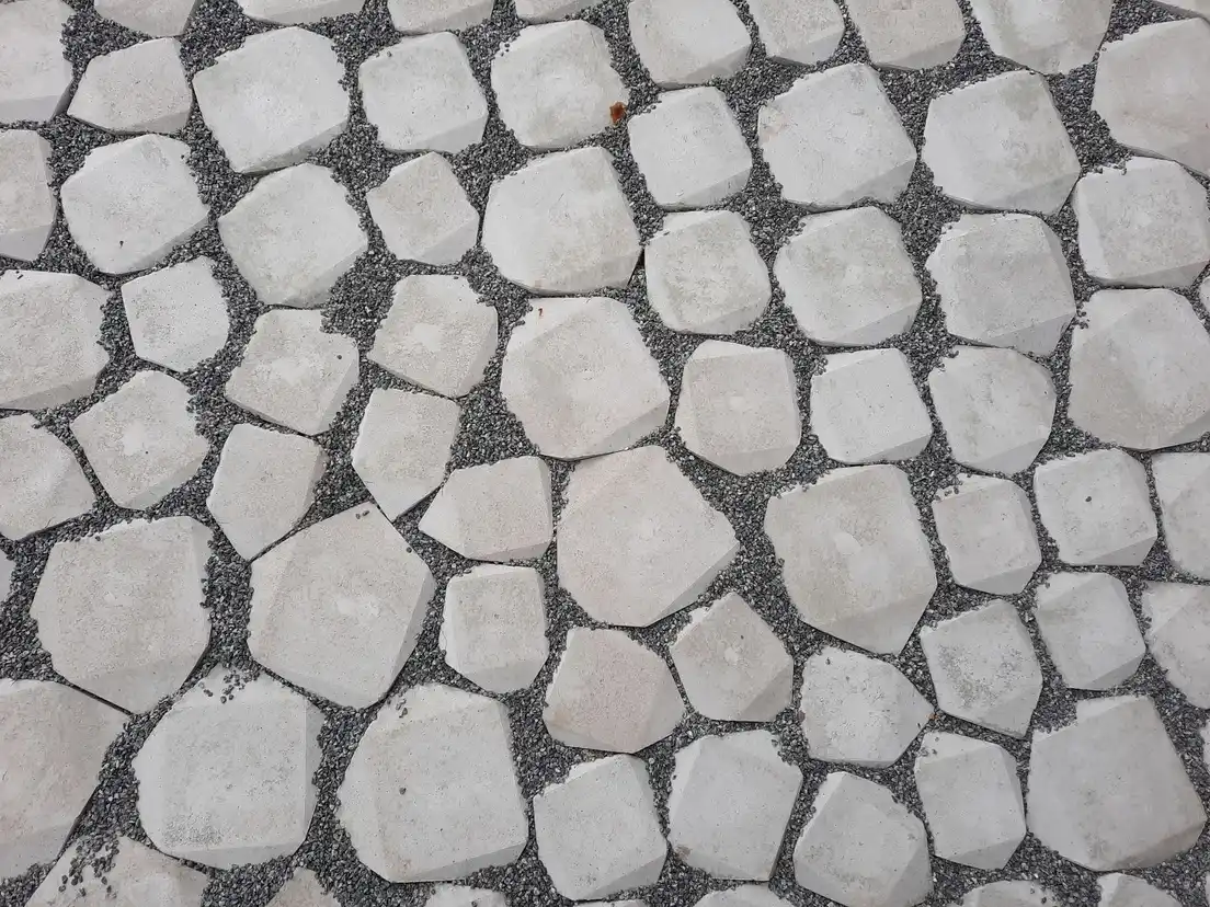 Irregular concrete pavers set into pea gravel forming a garden patio surface