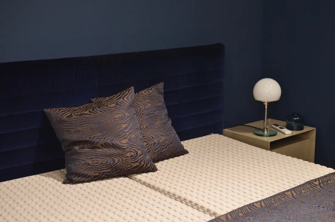 A navy upholstered headboard blending into a matching navy bedroom wall