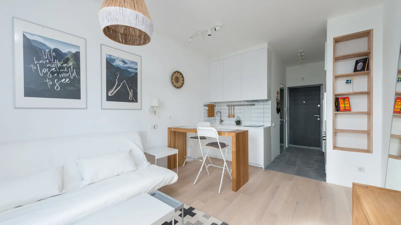 A small minimalist living room with light furniture and an open floor plan in a compact apartment