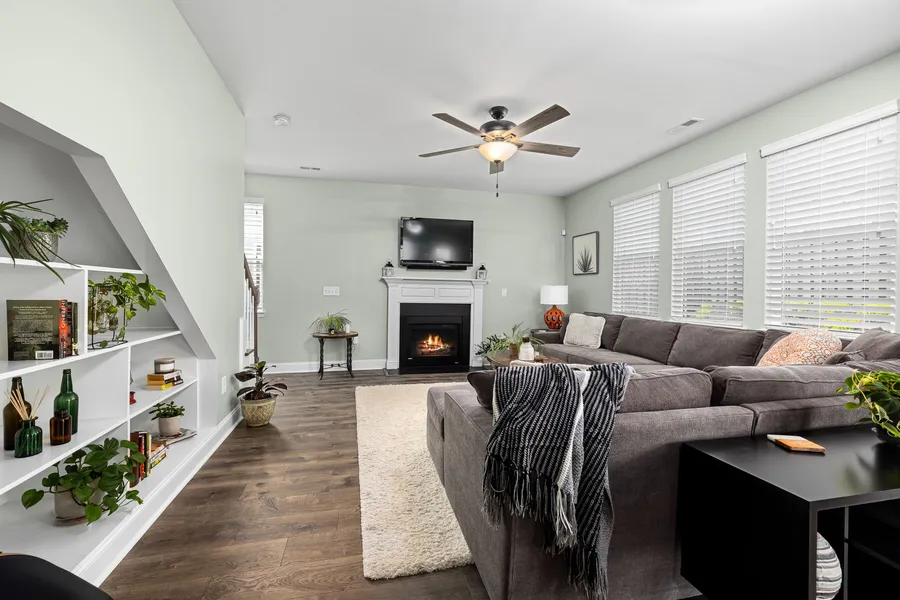 A small living room layout with a gray sectional sofa facing a fireplace and TV