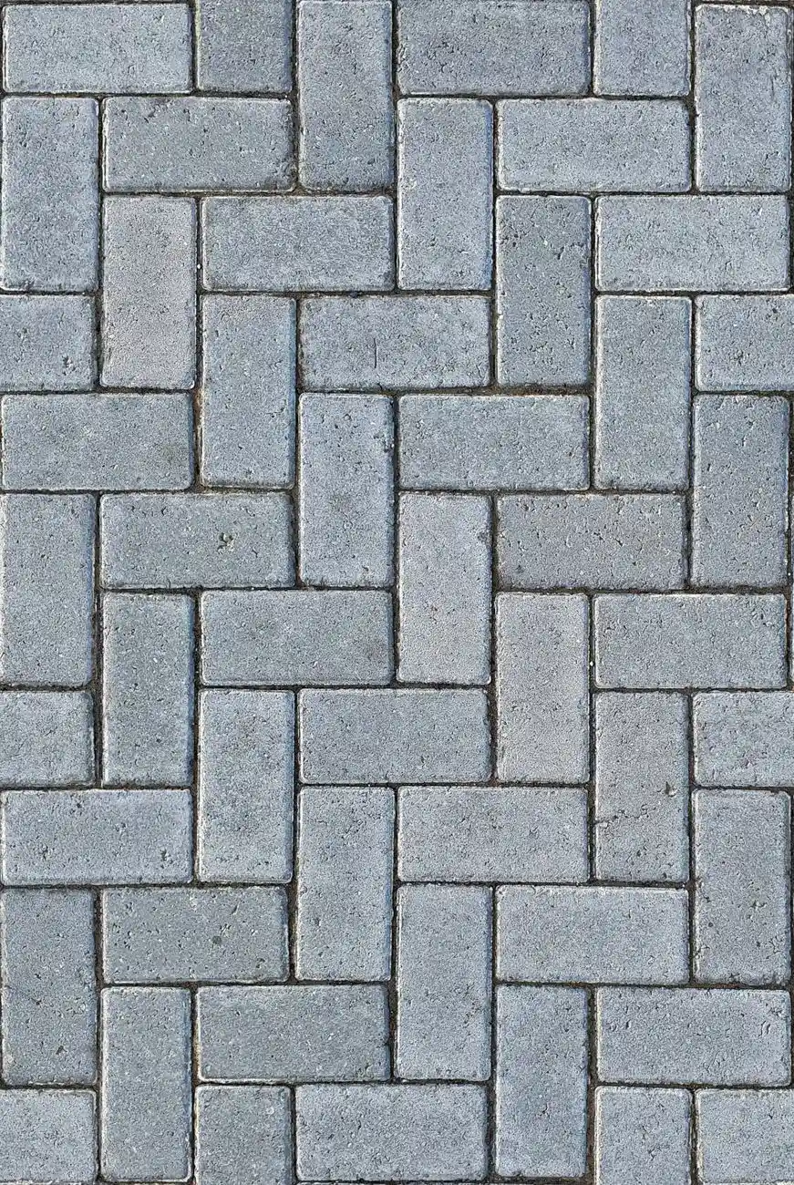 Close-up of gray concrete pavers laid in a herringbone pattern