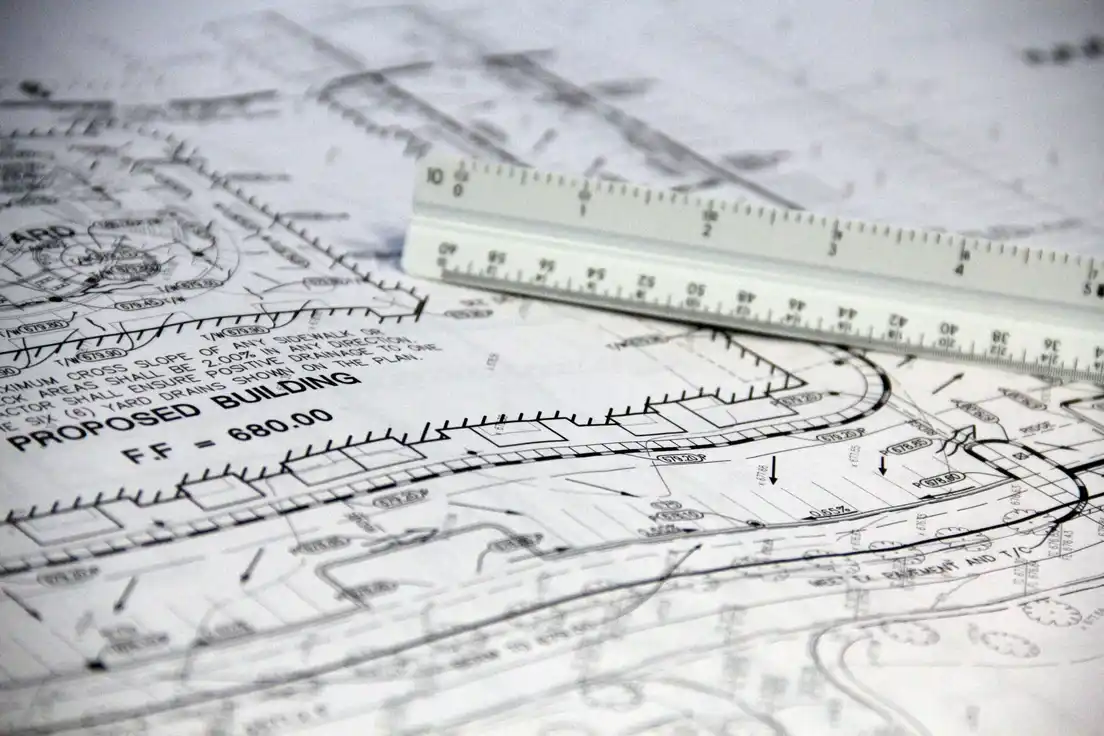 Building plans and a scale ruler used to price patio cover permits and site work