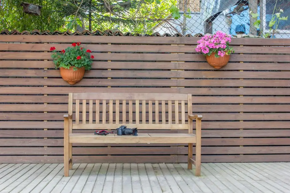 A wood privacy fence with hanging planters, the kind of structure HOAs regulate closely