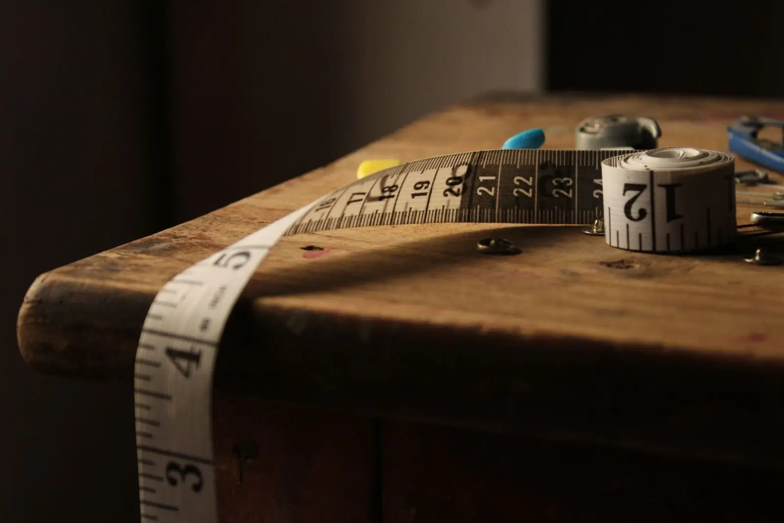 A tape measure on a wooden table, illustrating the honest math on multifunctional furniture for a small apartment