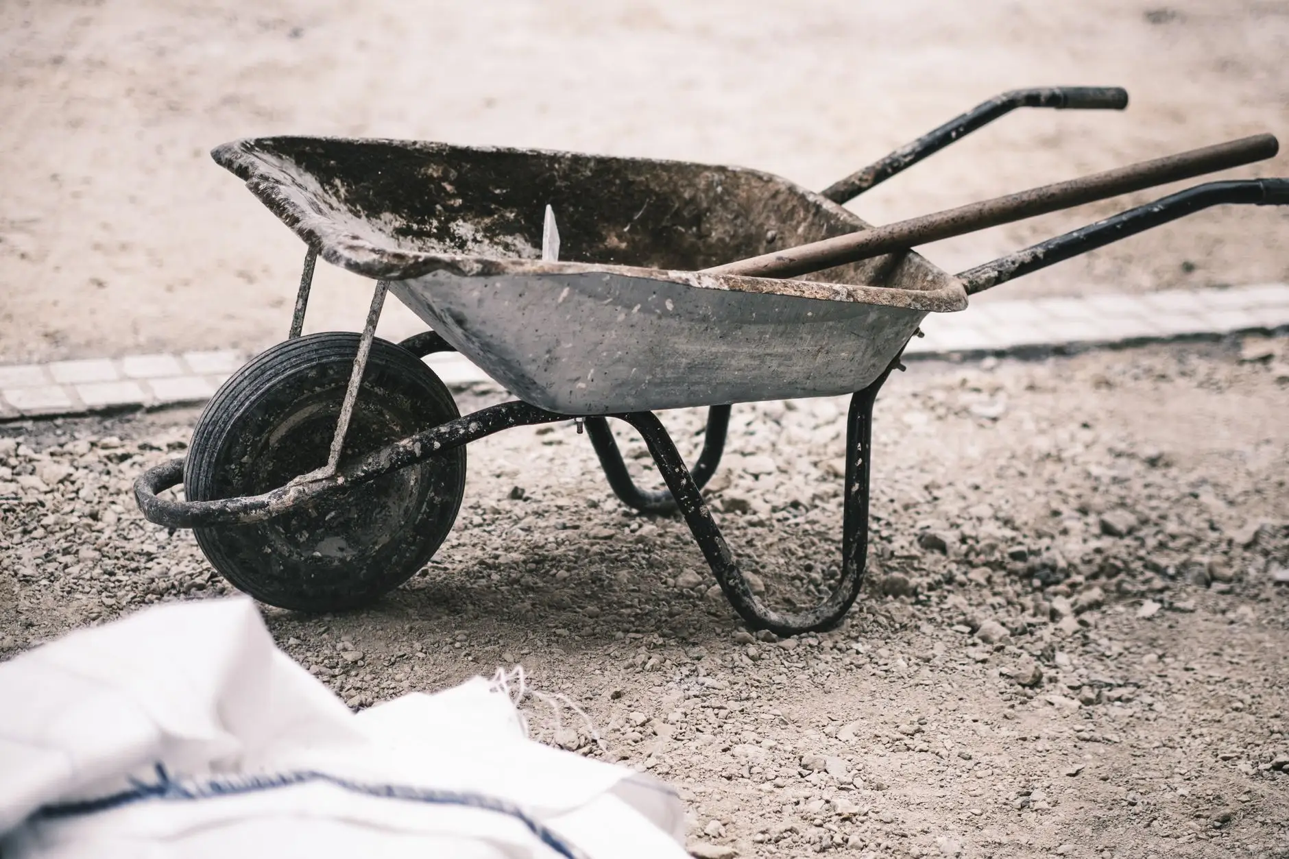 A wheelbarrow and shovel on gravel during a no-grass backyard project
