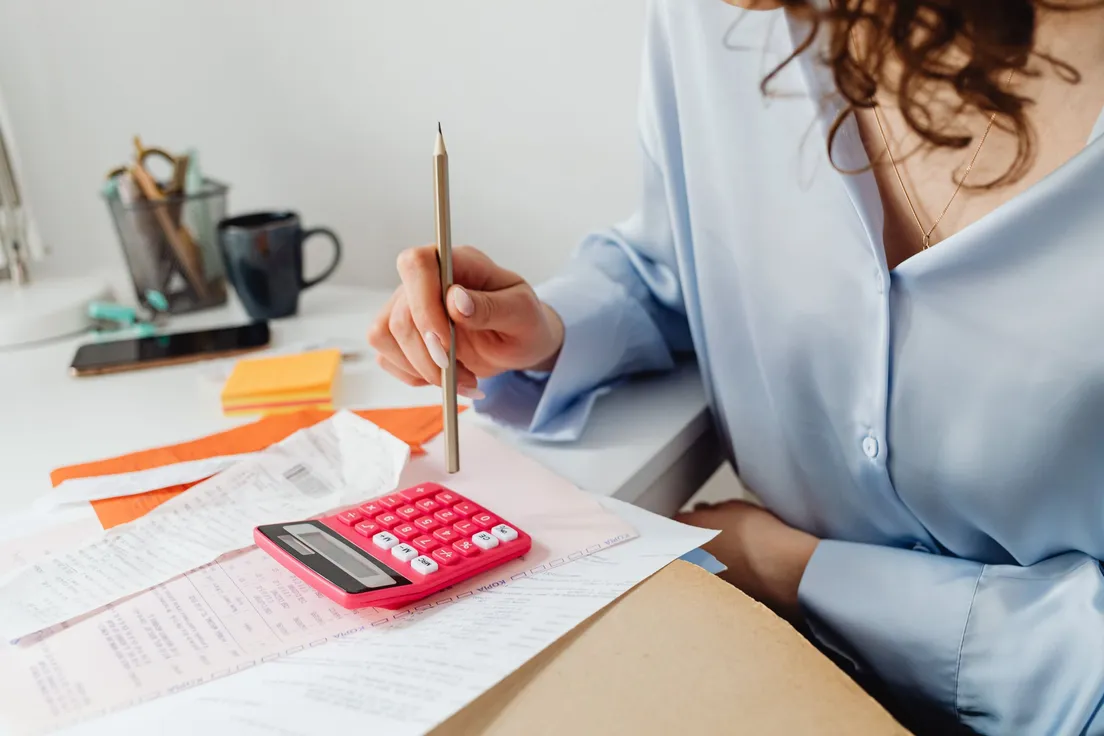 A person using a calculator and pencil to add up a kitchen renovation budget