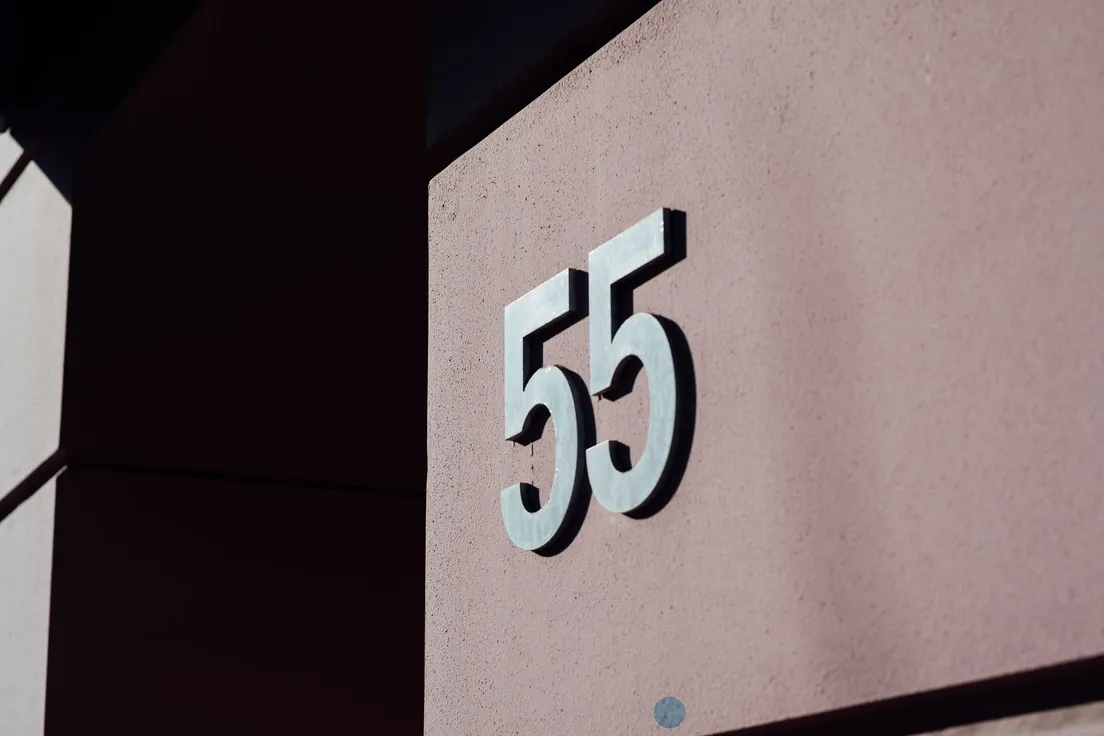 Large modern matte-black house numbers mounted on an exterior wall