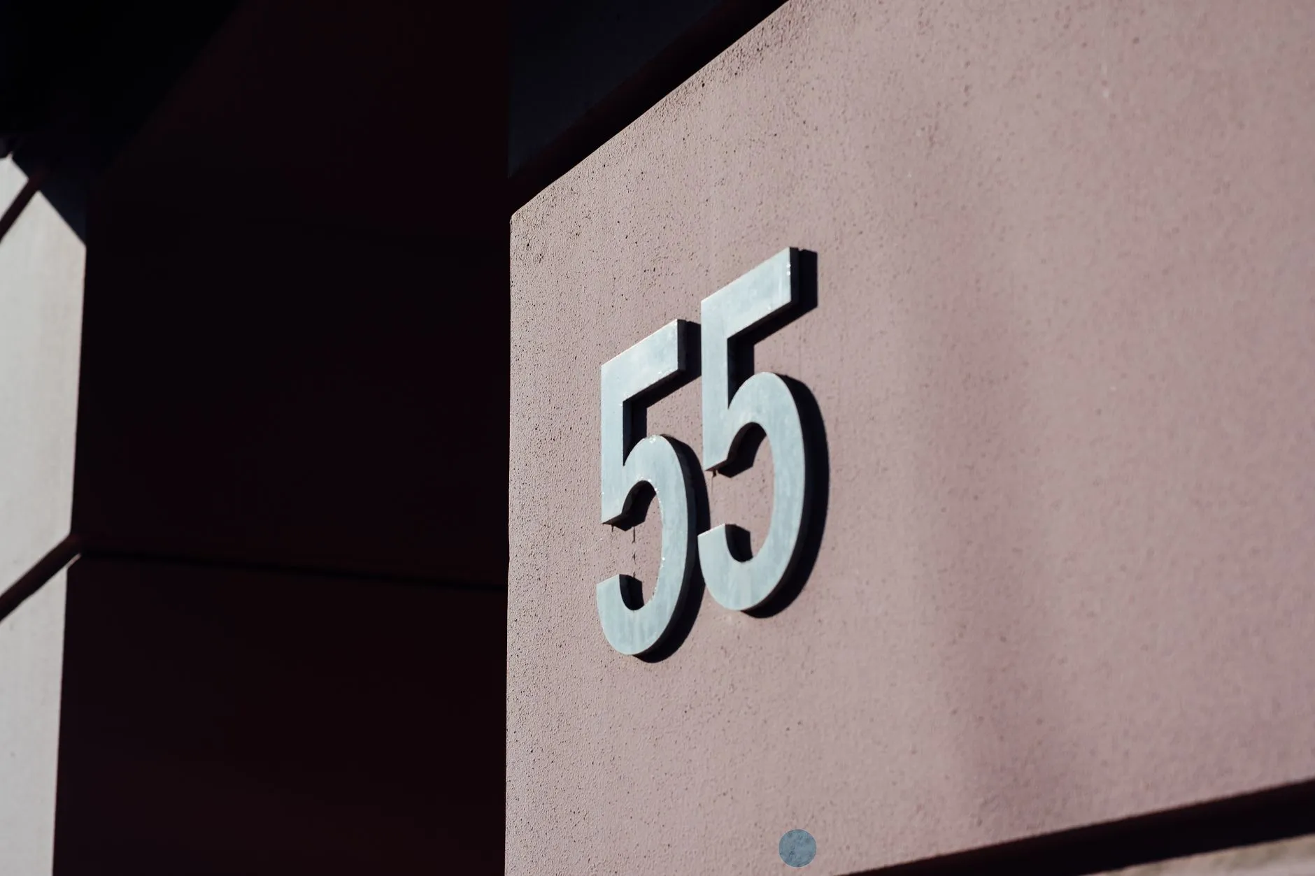 Large modern matte-black house numbers mounted on an exterior wall
