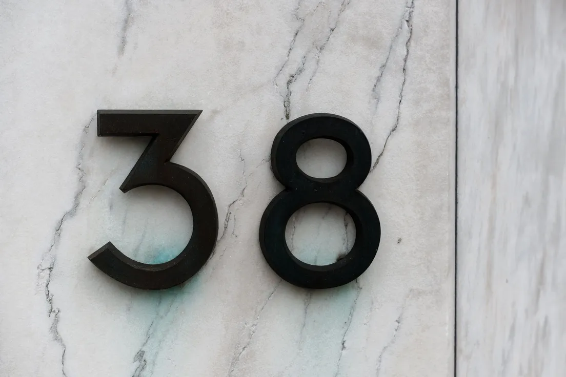 Modern black house numbers mounted on an exterior wall