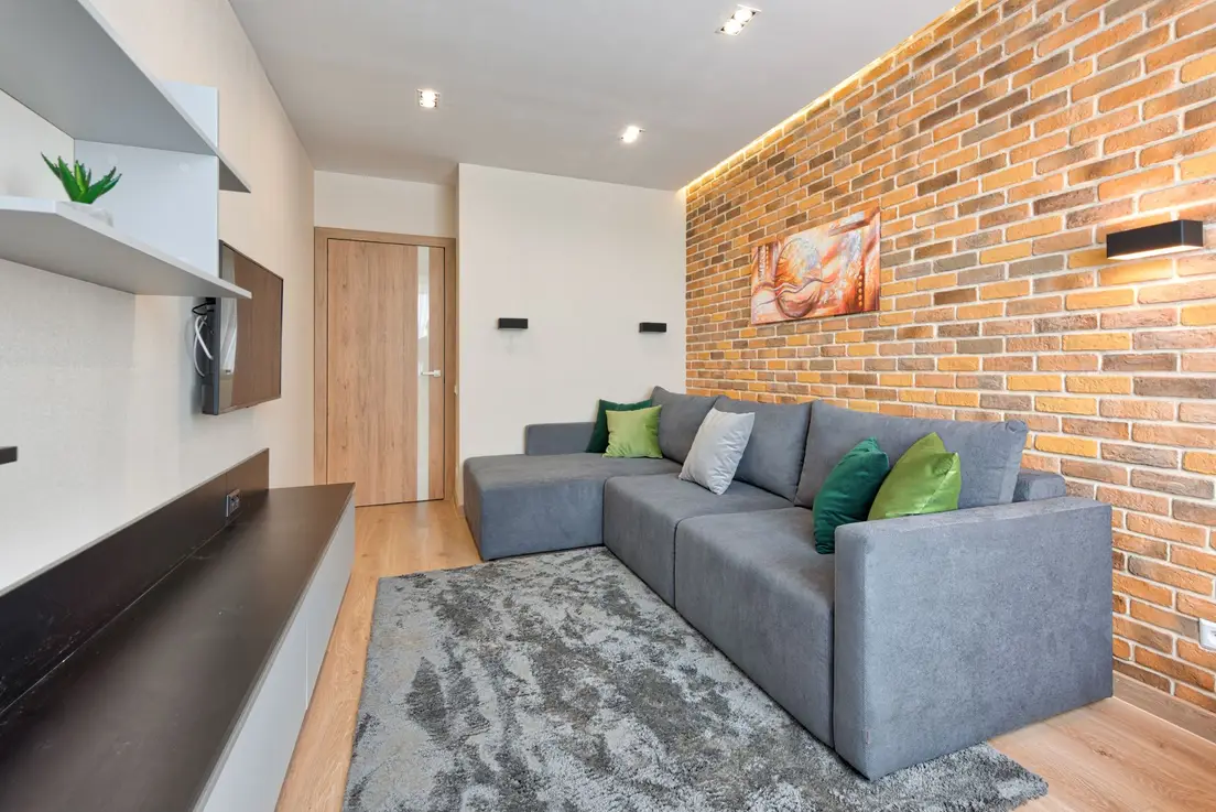 An L-shaped gray sectional sofa fitted into the corner of a small living room