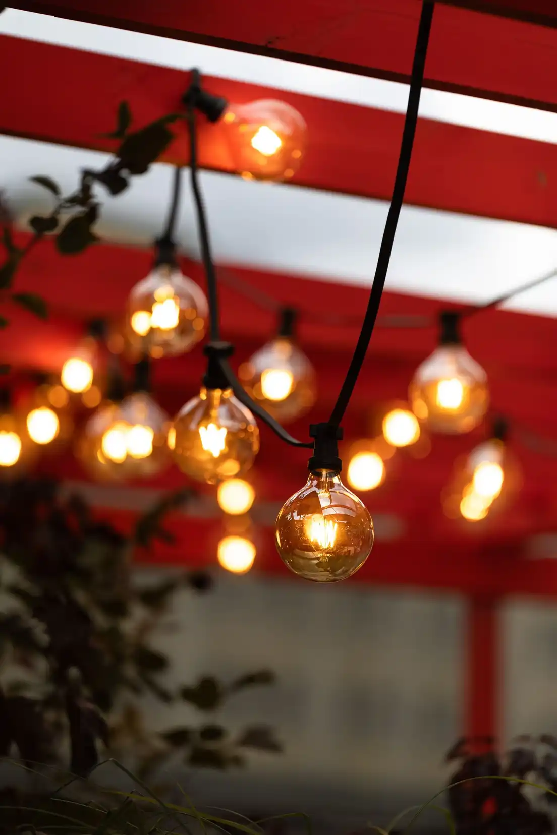 Warm string lights hanging from the beam of a patio cover structure