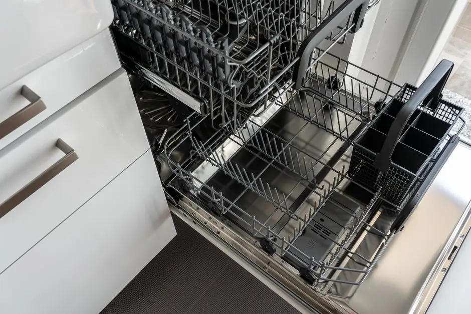 An open dishwasher with the lower rack pulled out in a white kitchen