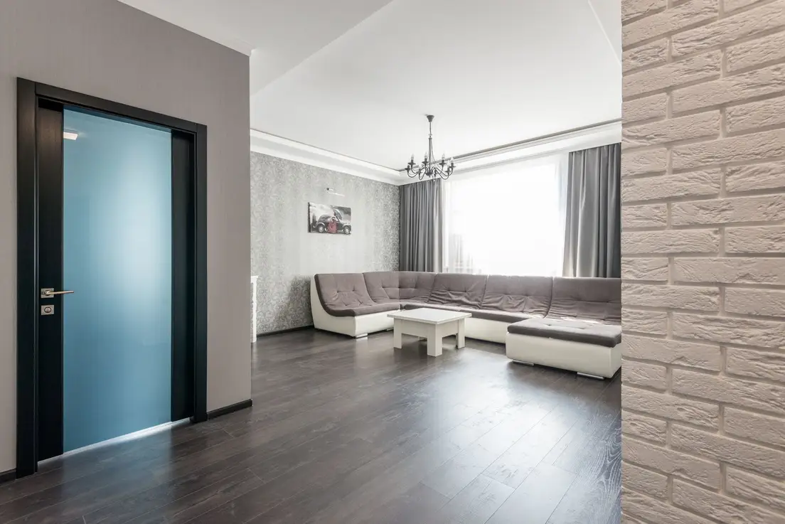 A sectional sofa positioned along the longest wall of a narrow small living room