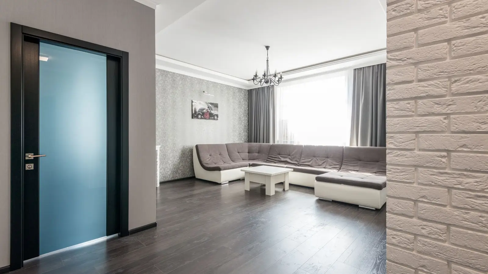 A sectional sofa positioned along the longest wall of a narrow small living room
